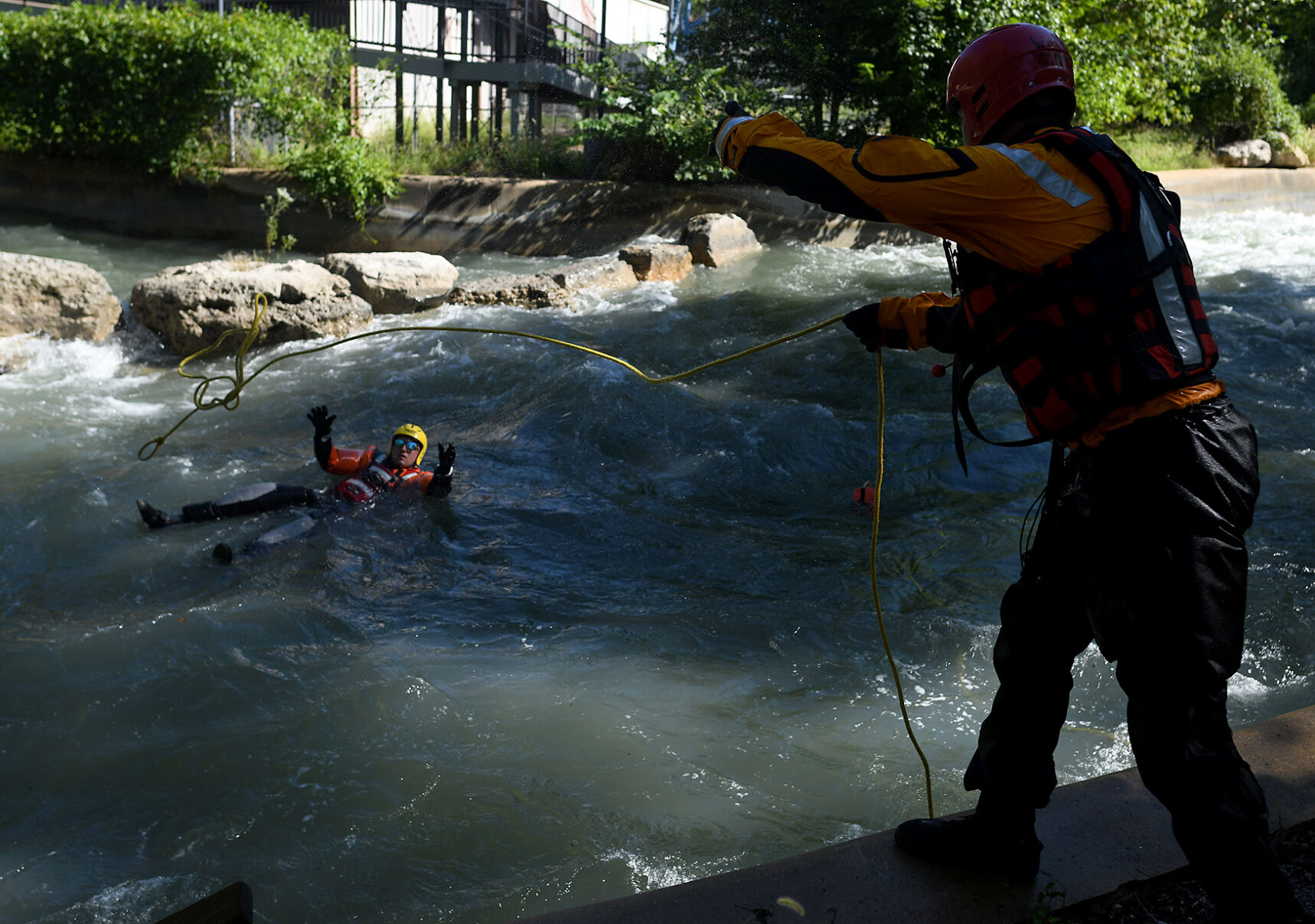 Edward Monser of the St. Louis Fire Department, right, throws a line of rope